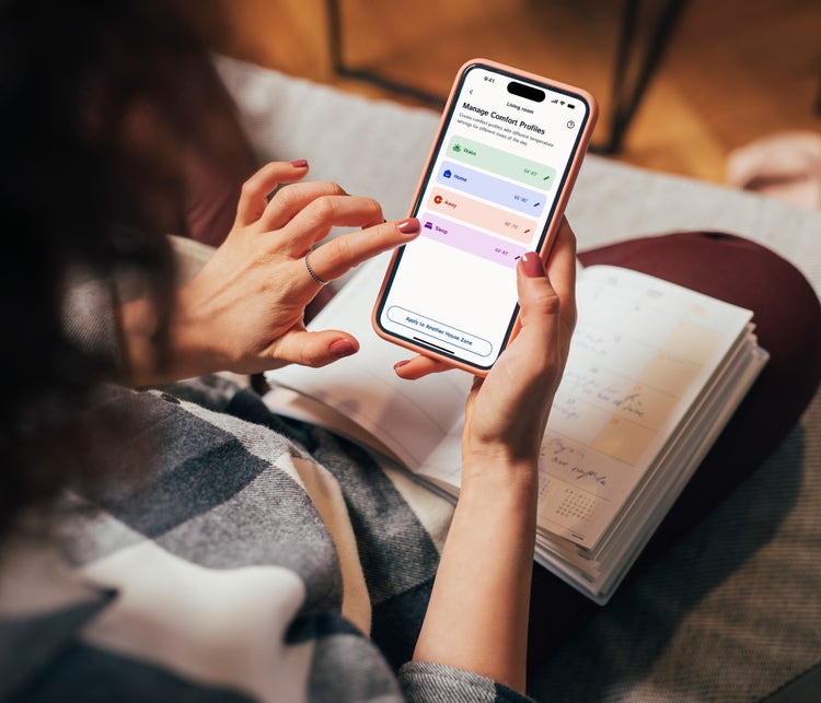 woman-using-the-smarthome-app-on-her-phone-to-manage-comfort-profiles